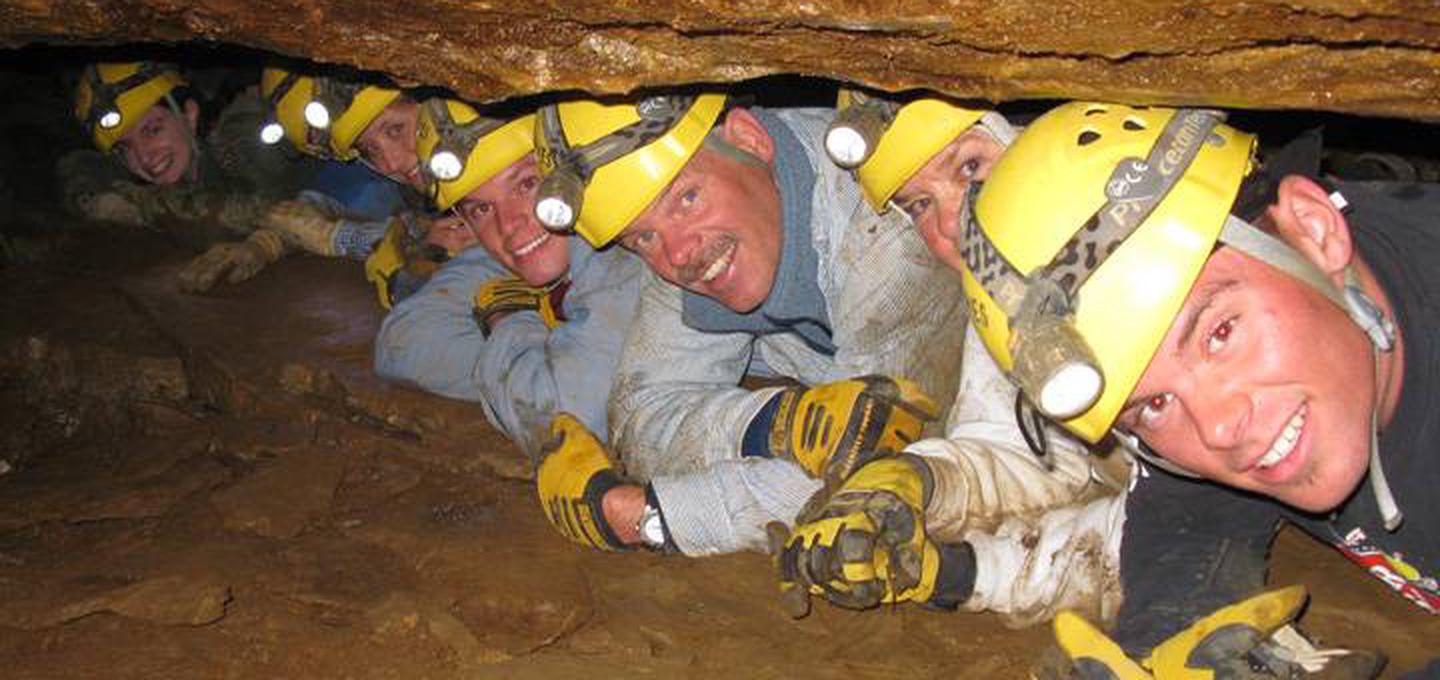 7 Cavers in a line between boulders