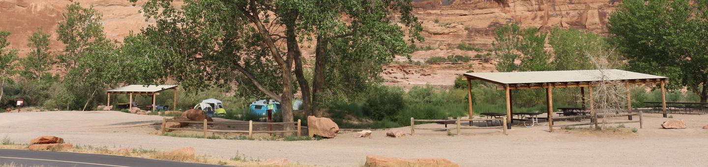 Group Site A & B at the Goose Island Campground including shade shelters, large cottonwood tree, and red rock cliffs behind.Goose Island Campground Group Sites A & B