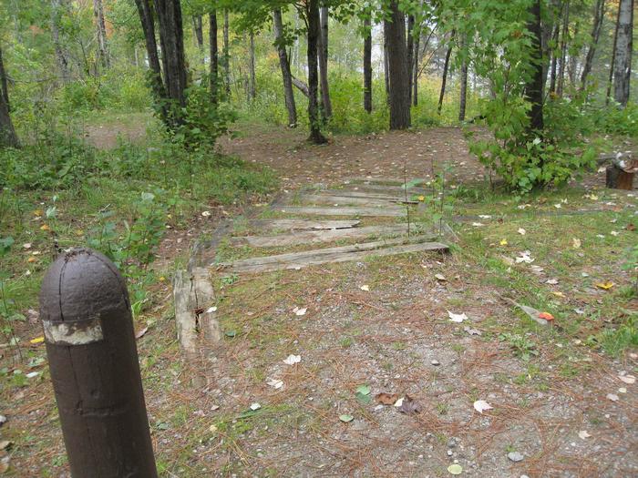 Picture of steps leading to campsite.Campsite suitable for vehicle and trailer.  Picnic table and fire ring are accessed via steps.