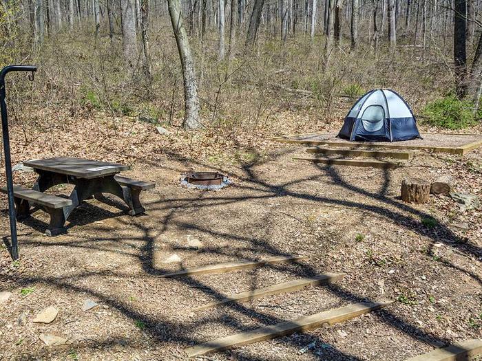campsite with picnic table, fire ring, tent pad and blue tent and stairs to siteOwens Creek Site #46