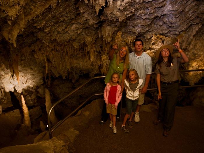 Family enjoying cave tour with rangerFamily in Chimes Chamber
