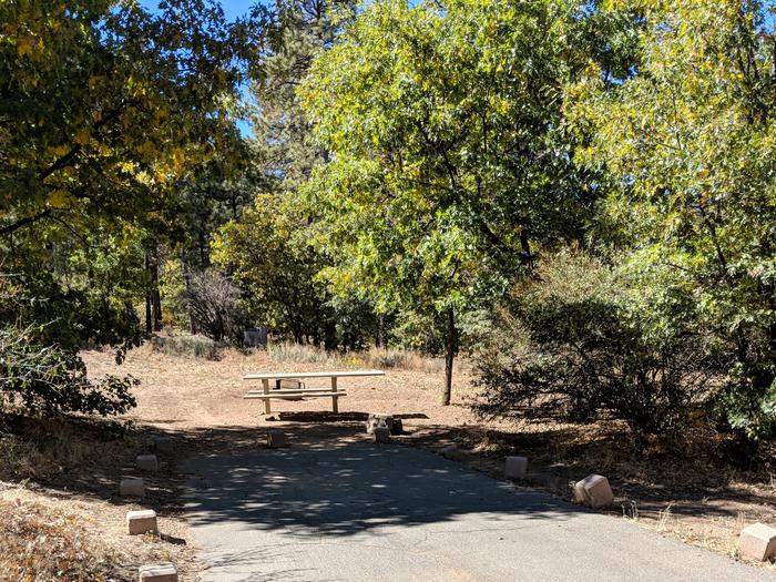 Burnt Rancheria Campground Site #6 featuring entrance to the wooded site and picnic table.