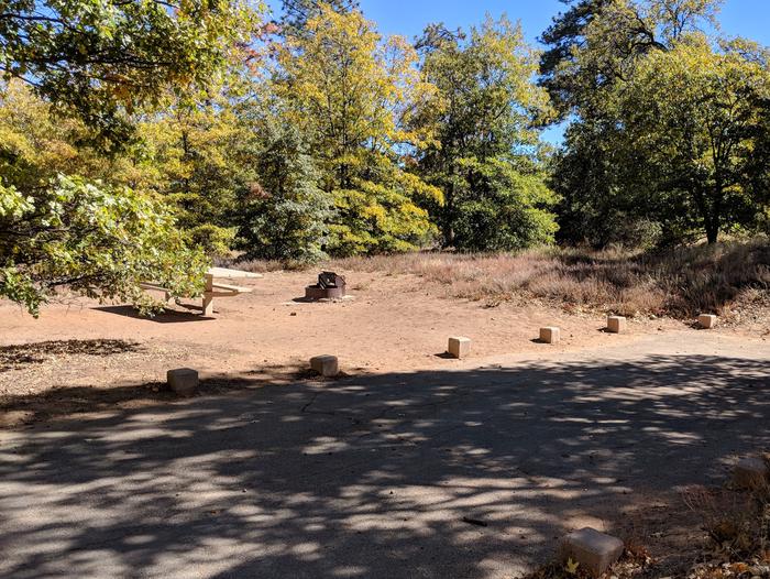 Burnt Rancheria Campground Site #7 featuring entrance to the wooded site and picnic table.