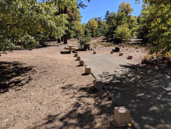Burnt Rancheria Campground Site #16 featuring entrance to the wooded site and camping space. 