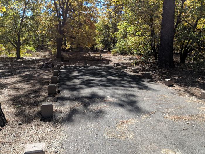 Burnt Rancheria Campground Site #19 featuring entrance to the wooded site and camping space. 