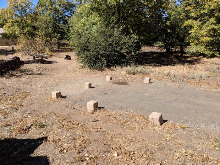Burnt Rancheria Campground Site #49 featuring entrance to the wooded site and picnic table.
