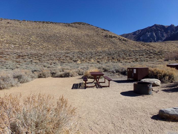 Convict Lake Campground site #50 featuring picnic table, food storage, and fire pit backing up to mountain. 
