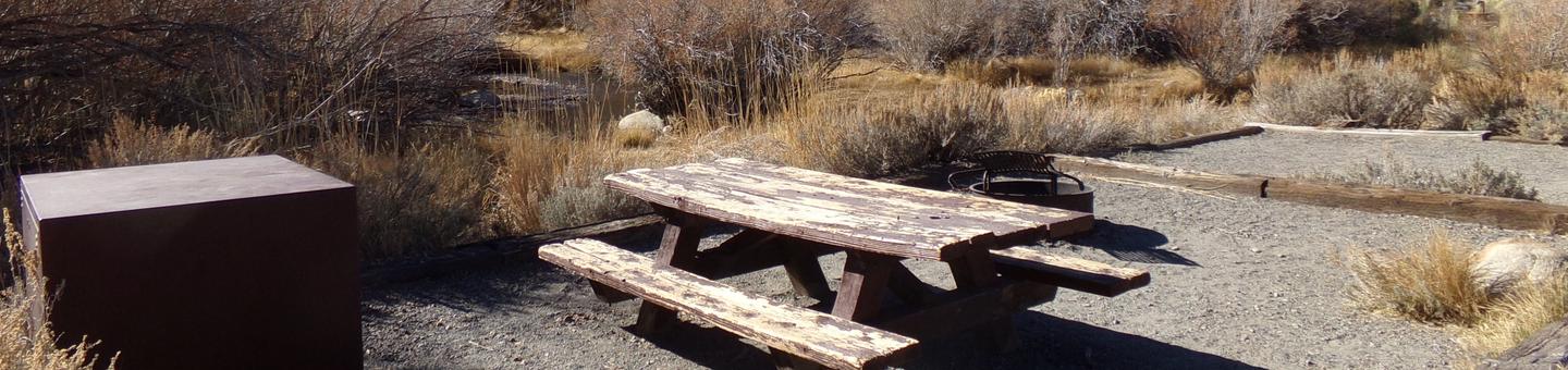 Convict Lake Campground creekside site #53 featuring camping space, picnic table, and food storage. 