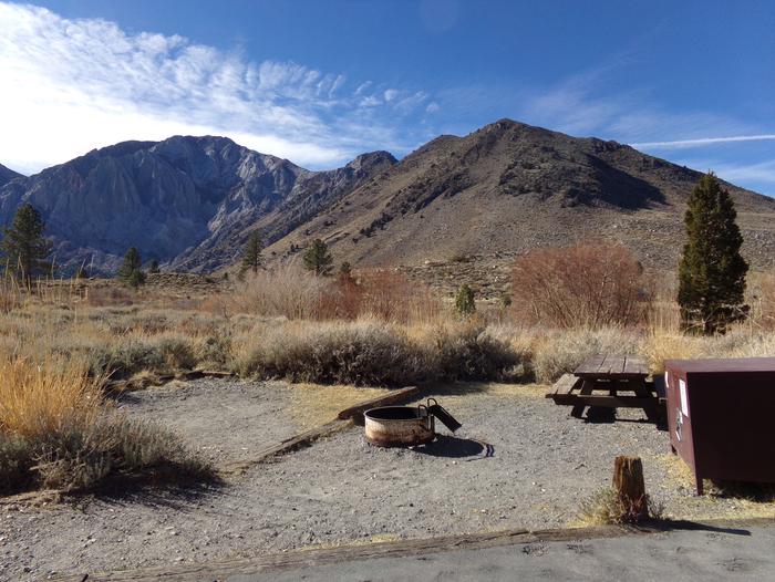 Convict Lake Campground site #64 featuring picnic area with food storage, fire pit, camp space, and mountain views.