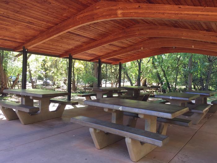 Wooded ramada with plentiful picnic tables and views at Crescent Moon. 