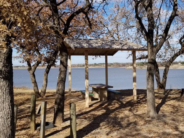 Site 16View of Site 16, including covered picnic table, shade trees, and lake view