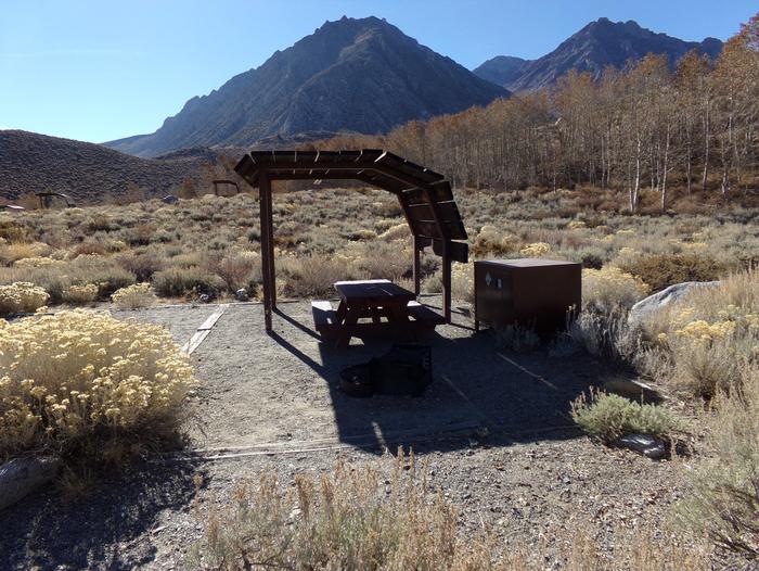 McGee Creek Campground site #16 featuring shaded picnic area with fire pit and camping space. 