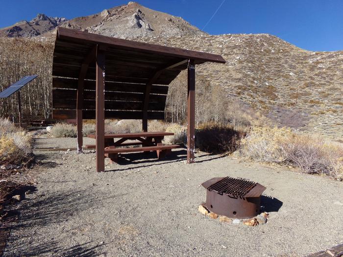 McGee Creek Campground site #21 featuring shaded picnic area with fire pit and camping space. 