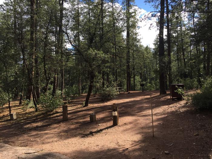 Ponderosa Campground site #A-03 featuring wooded camping space with picnic area and fire pit. 