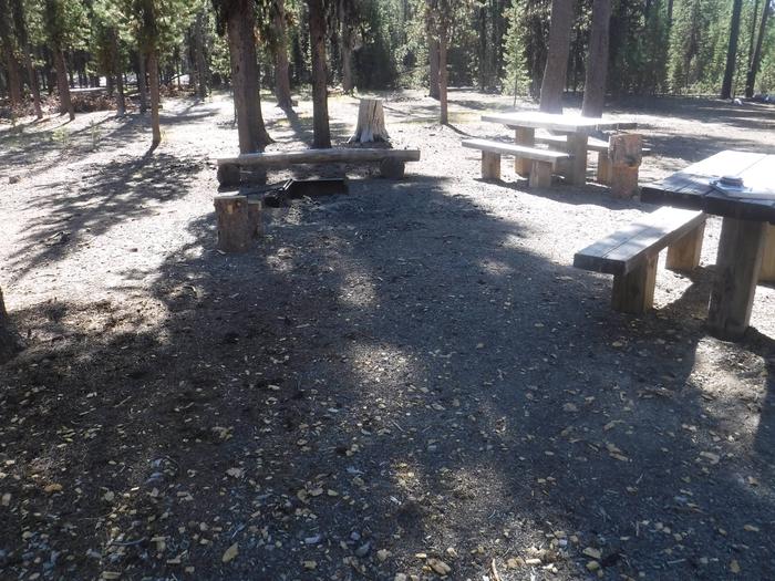 Flat campsite with two picnic tables and a fire ring. J-08