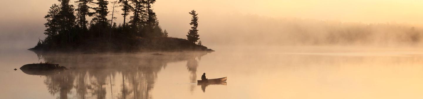 Paddler drifting on the water in Boundary Waters Canoe Area Wilderness. 