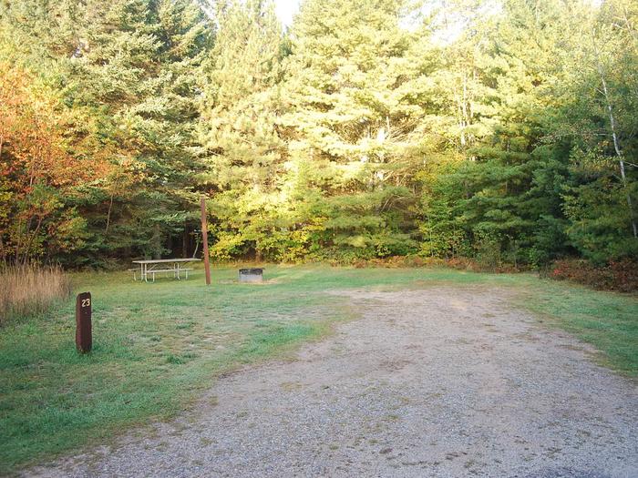 Bay Furnace Campground site #23; heavily treed site with picnic table and fire pit. 