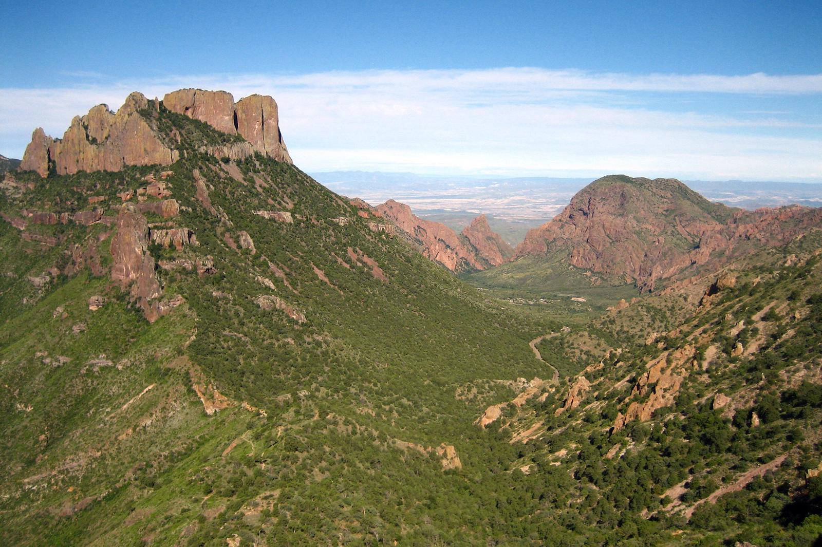 View of Chisos Basin from the Lost Mine trail. Green vegetation with red mountainsView of Chisos Basin from the Lost Mine trail
