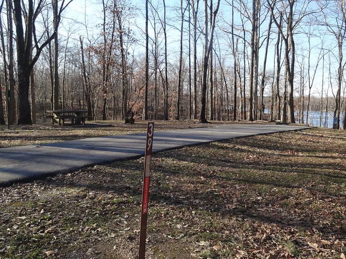 This site has a picnic table and fire pit on the left side of the paved pads. The hookups for this site are located to the right rear side of the paved parking pad. This site is near the waters edge and has an additional pad for camping supplies. 