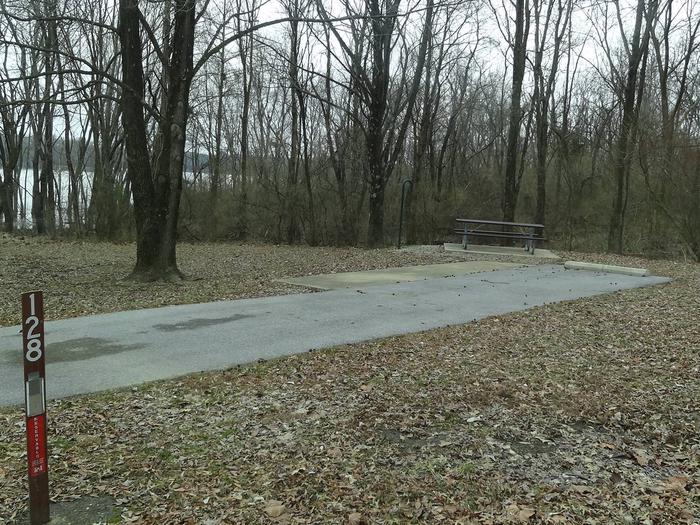 picnic table and fire pit located to the left of camp pad, electric located to the right of pad. site located near water