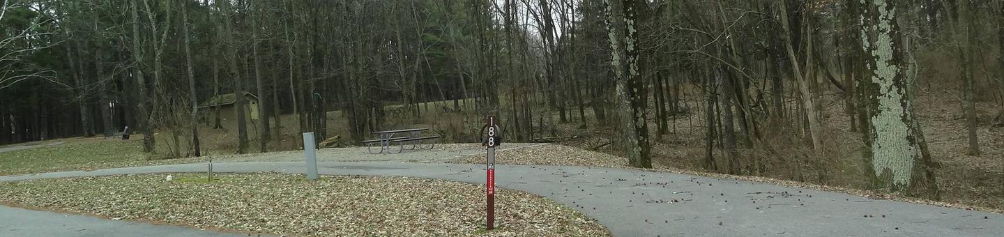 Pull through type site with picnic table and fire pit on the right of camp pad, and water and electric on left of camp pad