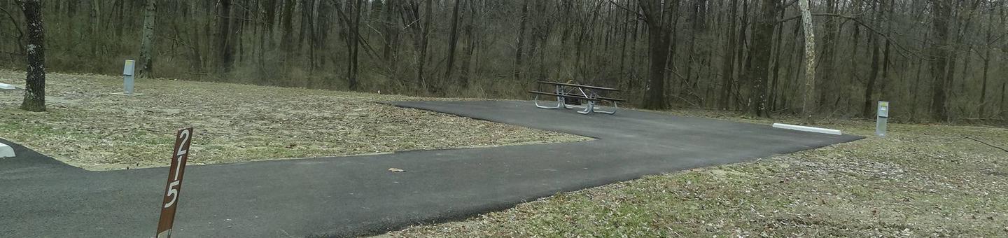 picnic table, fire pit, and extra parking to the left of camp pad, electric to the right of pad.