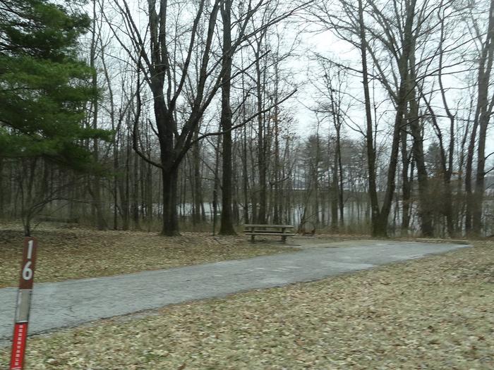 picnic table and fire pit to the left of camp pad, electric to the right of pad.