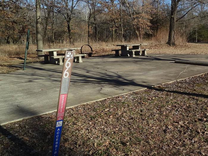 This is a handicap accessible site with full hookups. This site has two picnic tables and a fire pit located on the left side of the paved parking/camping pad.  It is near a playground and drinking fountain. 