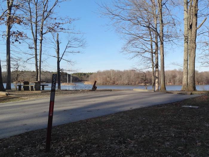 This site has a perfect view of the lake. Picnic table and fire pit are located to the left of the paved parking/camping pad. The hookups are on the right side of the pad. This site has a picnic table and fire pit to the left side of the paved parking/camping pad. The hookups are on the right side of the pad. There is a tree line on the right side of the pad also. 