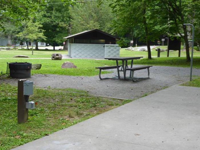 Picnic table and fire ringADA sites have paved parking pads and taller fire rings. 
