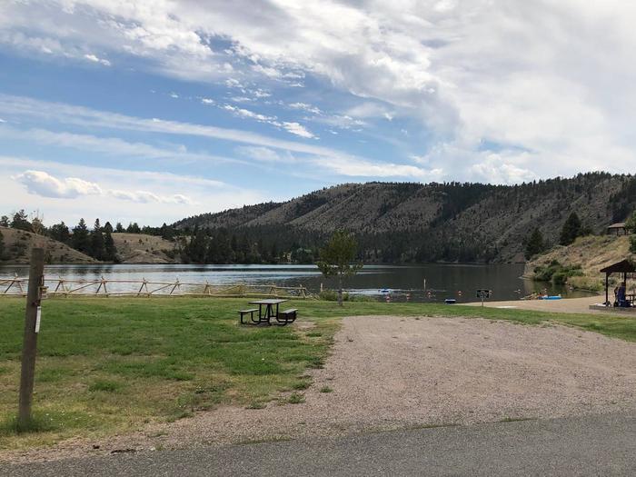 Site 1 White Sandy Campground. Adjacent to beach/swimming area. Lakeside campsite. Gravel camping pad with picnic table and fire pit. Paved access within campground.Site 1 White Sandy Campground.