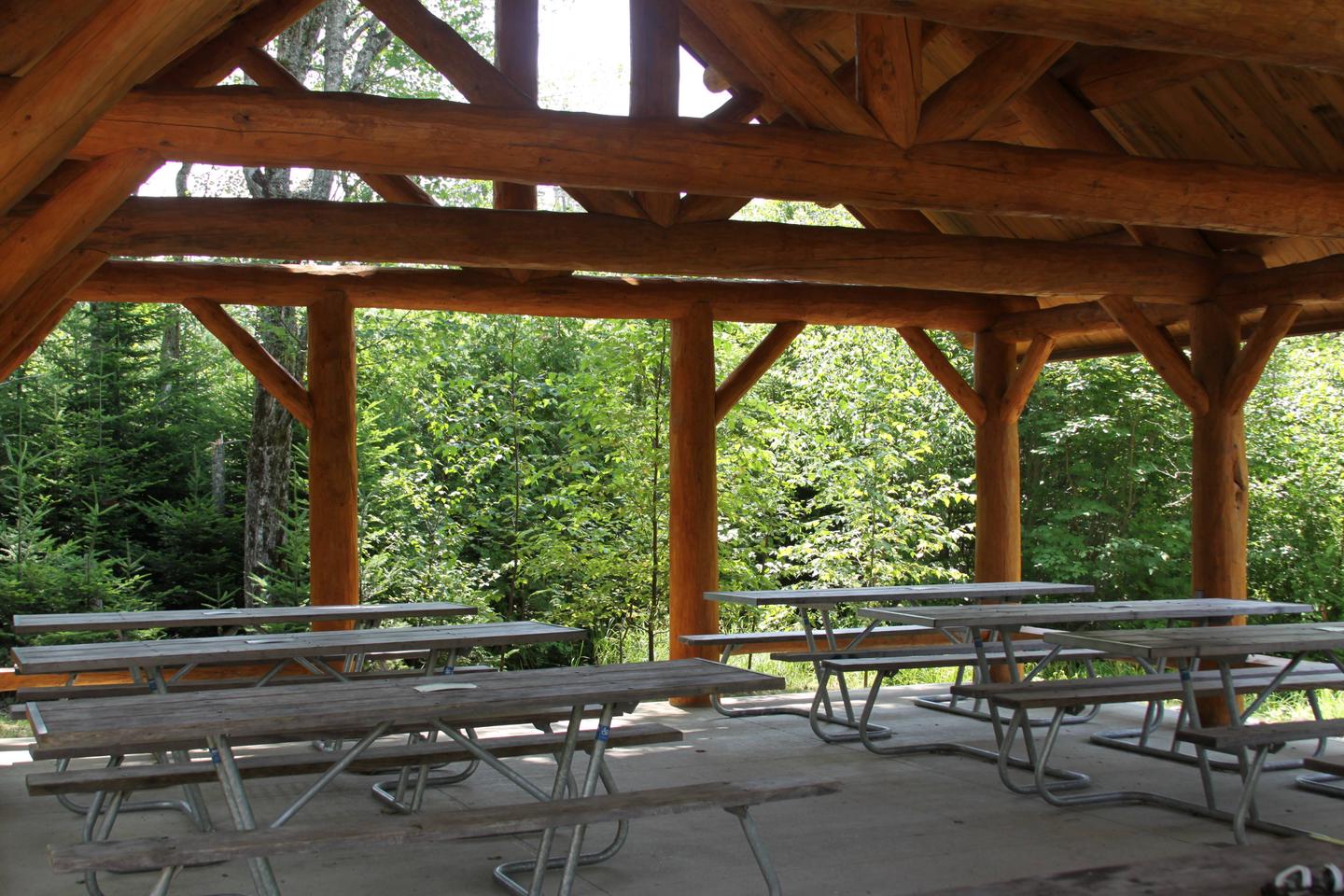 Interior view of log cabin style picnic pavilion with accessible picnic tables.Pavilion for group campsites (Photo 2 of 2)