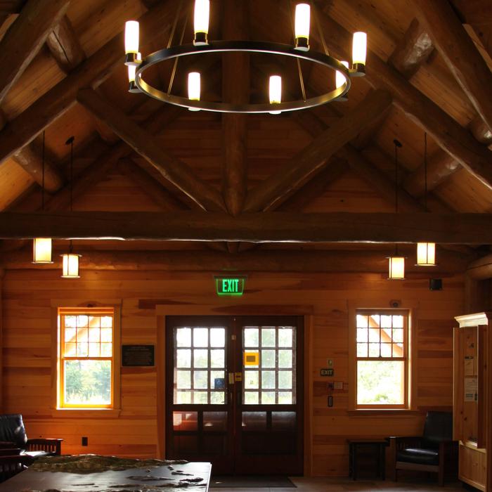 Interior of log cabin style ranger station with vaulted ceiling and large chandelier. Inside Schoodic Woods Ranger Station (Photo 1 of 2)