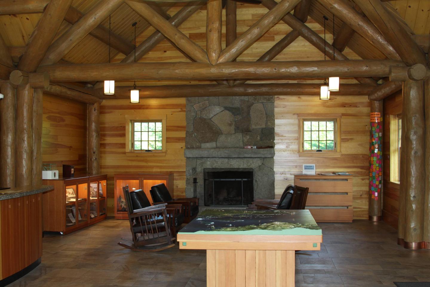 Interior of log cabin ranger station with stone fireplace, rocking chairs, and wildlife displays.Inside Schoodic Woods Ranger Station (Photo 2 of 2)