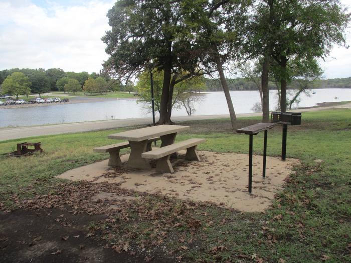 Site 26 - Rocky PointSite 26 offers a concrete picnic table, pedestal grill, utility table, lantern holder and fire ring.  It also offers a great view of the lake.