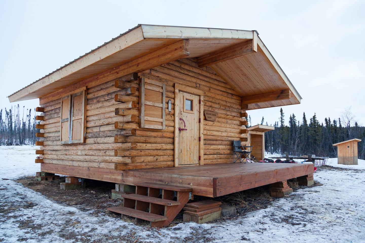 A log cabin in a snowy meadowMoose Creek Cabin in winter
