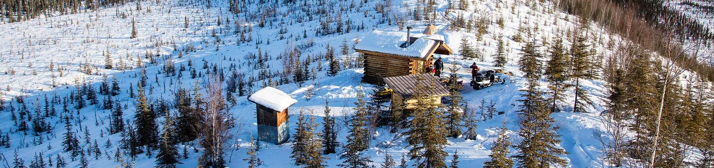 Cabin and outbuildings on a ridge in winterCaribou Bluff Cabin