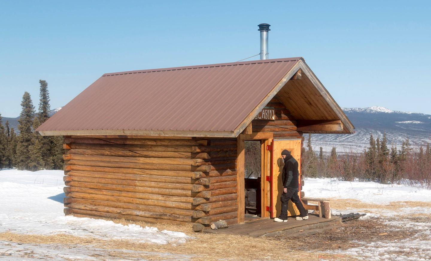 Man walks into a cabin in a snowy clearingLee's Cabin