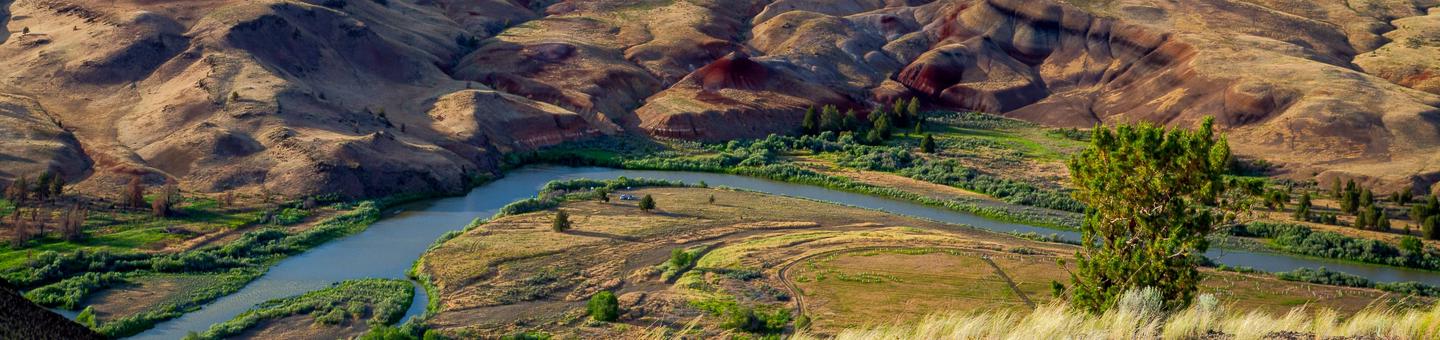 The John Day River winding through red and yellow clay hills The John Day River near Priest Hole.