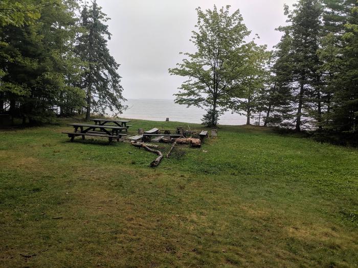 Sand site A with two picnic tables, fire ring, and lake viewSand Site A