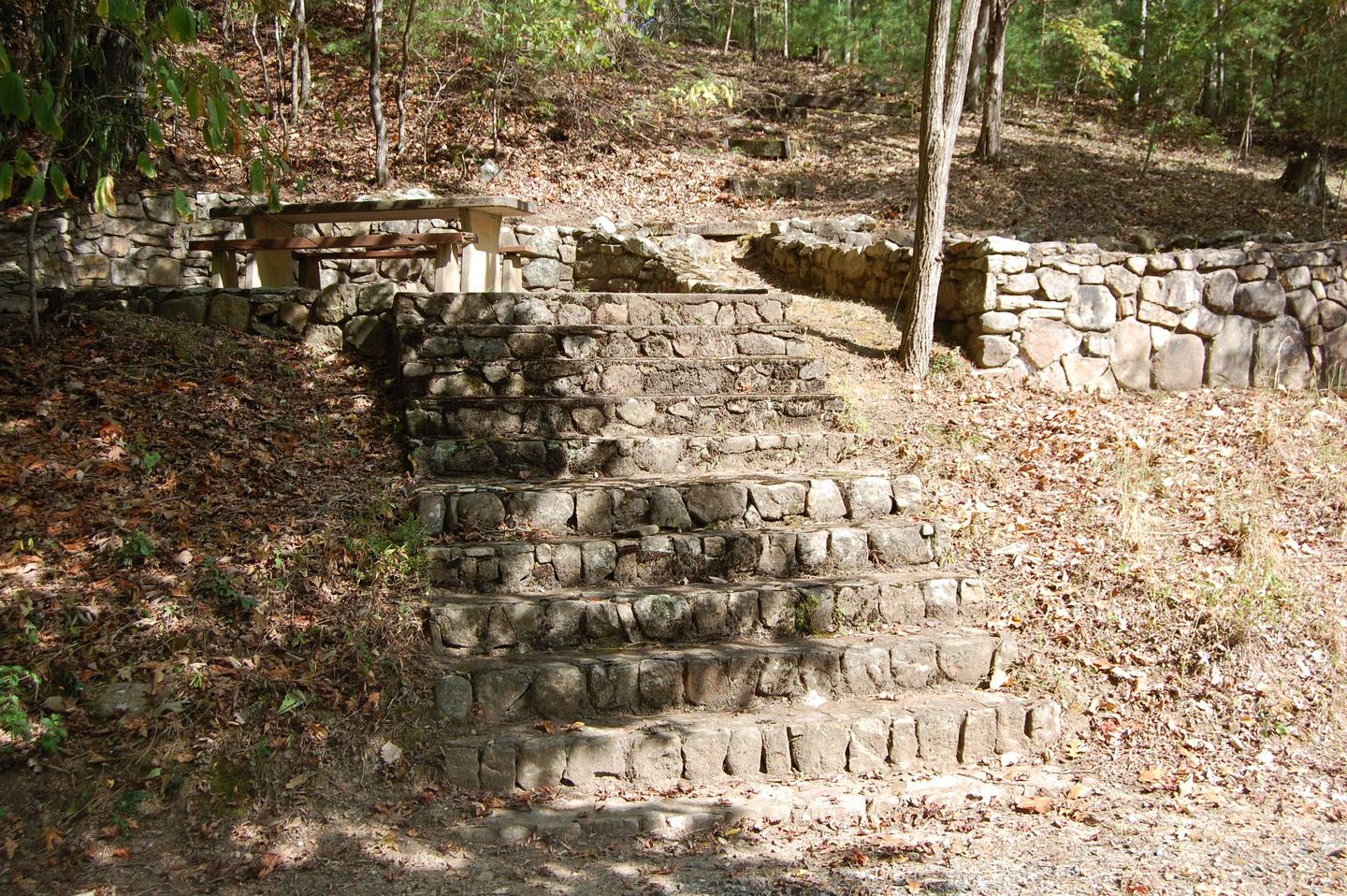 12 Stairs Site is in a desirable private wooded area of the campground. Stairs lead up to a shaded picnic area and tent pad. 