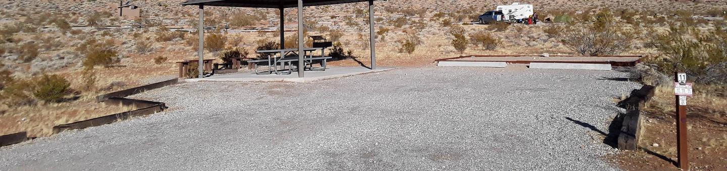 Red Rock Canyon Campground Standard Site 11Red Rock Canyon Campground Standard Site that has a shelter with a picnic table on a cement slab. There is also a nice fire pit with seating. A  large tent pad and plenty of parking for two vehicles or a recreational vehicle and vehicle as well.