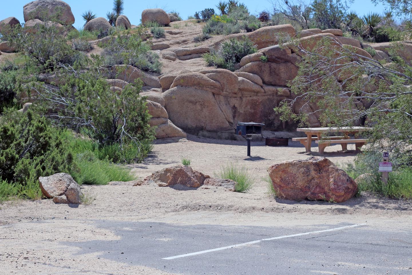 Shared parking for campsite. Picnic table surrounded by boulders and green plants.Shared parking for campsite.