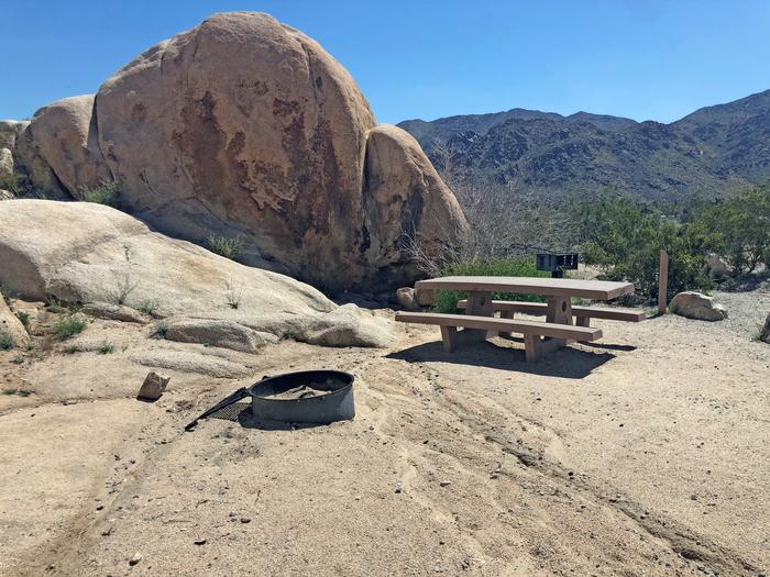 Campsite  with picnic table surrounded by boulders and blue sky.Campsite.