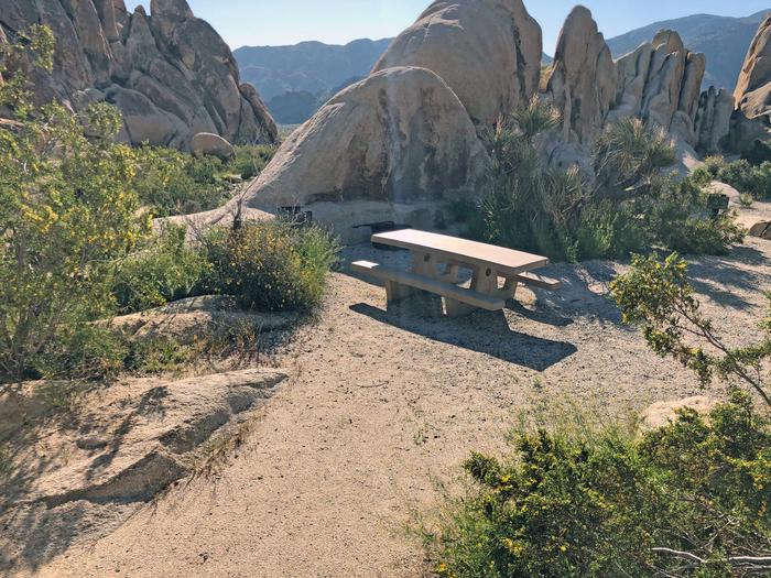 Campsite  with picnic table surrounded by boulders mountain views.Campsite.