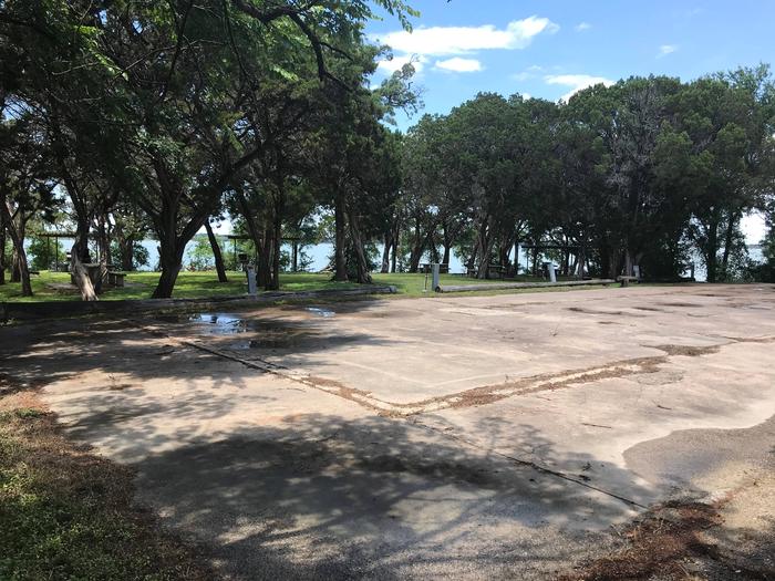 RV hookup area with picnic tables in backgroundRV hookup area with view of Waco Lake