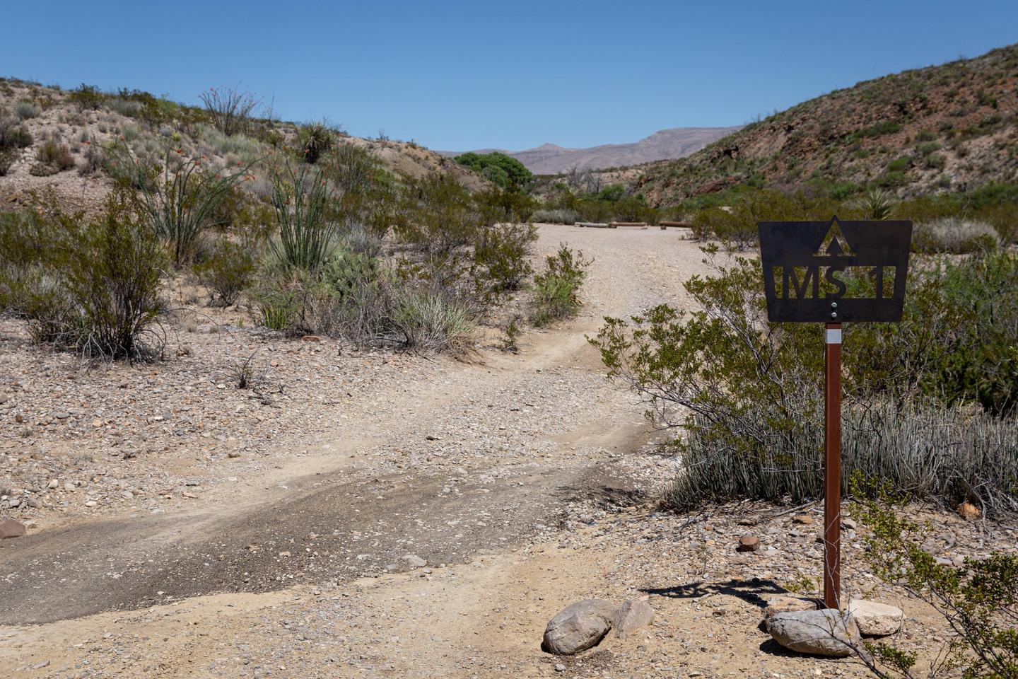 Campsite nestled between desert hillsAccess and campsite marker 