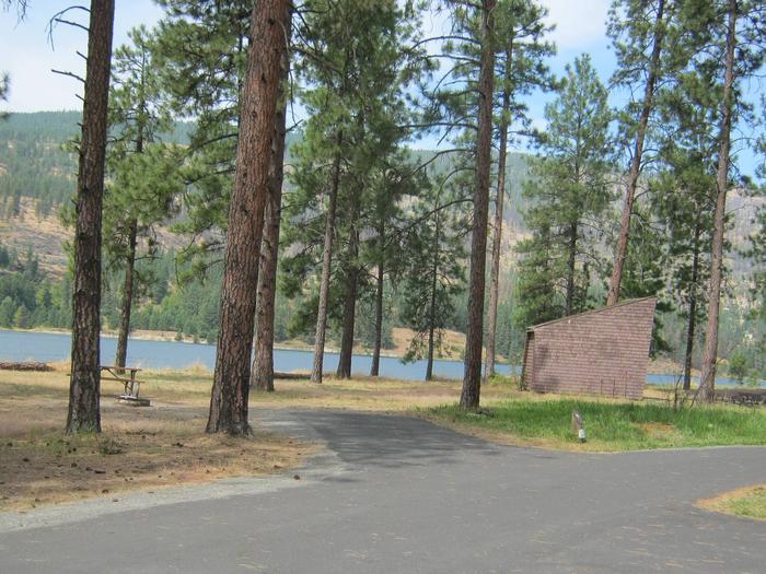 Pine trees and lake in the back dropBack in paved parking