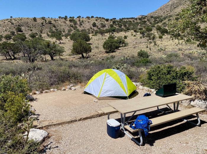Tent site number seven, displaying a two-person tent on tent pad and view of hillside in background.