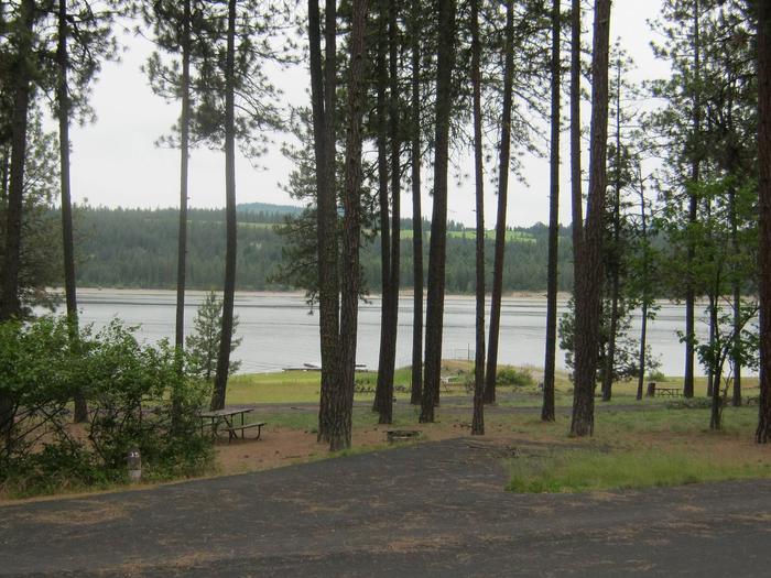Site #35 Back in site, paved with trees and lake in the background.Site #35